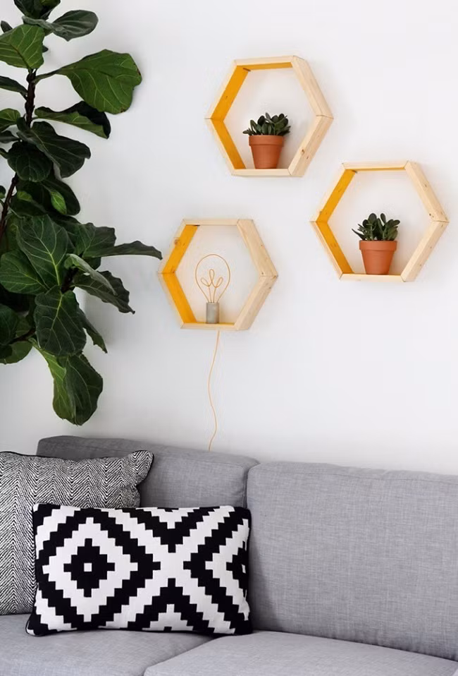 Nếu bạn đã chán ngán giấy dán tường thì hãy làm những chiếc khung hình lục giác đáng yêu và treo trên tường như thế này. Đặt một chiếc bóng đèn trong chiếc khung sẽ đủ để sưởi ấm cả góc phòng nhà bạn.