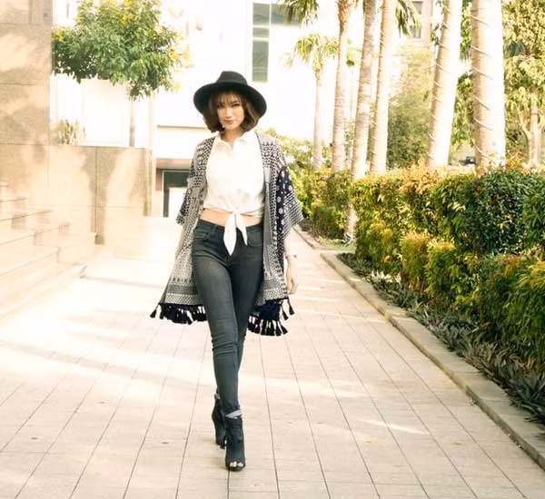 Cardigan kết hợp với áo sơ mi? Tại sao không? Nếu cho rằng cardigan không nên kết hợp với áo sơ mi vì trông chúng rất tệ thì bạn đã nhầm, nhầm to. Vì thiết kế duyên dáng và thanh lịch đặc trưng của cardigan khi được kết hợp cùng vẻ ngoài gọn gàng, lịch lãm của sơ mi trắng sẽ giúp người mặc có được “bộ cánh” hoàn hảo giúp bạn tự tin trong mọi hoàn cảnh. Rất phù hợp với những cô nàng kín đáo, cổ điển và đặc biệt là các chị em công sở. Áo sơ mi thắt bụng, áo choàng cardigan cộng thêm bốt cao cổ và mũ fedora cá tính như người đẹp Trương Tri Trúc Diễm.