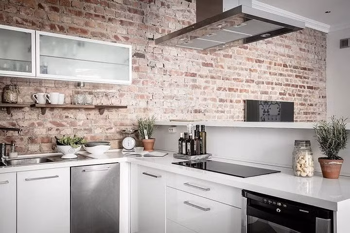 Trong không gian bếp này, những bức tường gạch thô không trát tạo nên sự đơn giản trong nội thất. Chủ nhà kết hợp với những thiết bị hiện đại, tạo nên sự độc đáo.