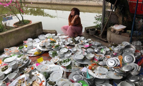 Bức ảnh cô gái ngồi cạnh 'núi' bát đĩa bẩn.