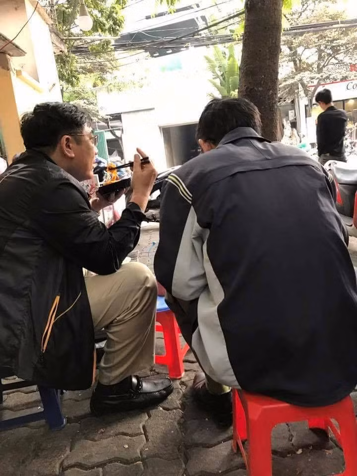 Bức ảnh hai người đàn ông trung niên đi ăn bánh tráng trộn cùng nhau.