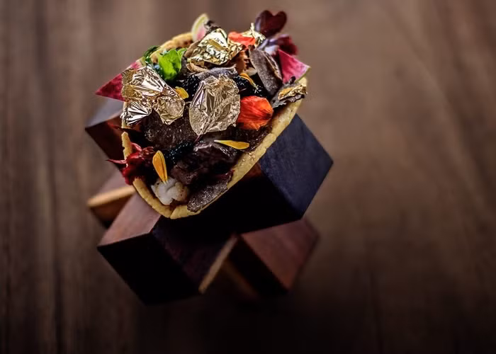 3.Taco đắt nhất Một số người đến Mexico để thưởng thức món ăn đường phố tuyệt vời và rẻ tiền. Một số đến để thưởng thức taco đắt nhất thế giới tại khách sạn Grand Velas Los Cabos. Chiếc Taco với giá đắt đỏ 570 triệu đồng có chứa tôm hùm langoustine, thịt bò Kobe, trứng cá muối Almas Beluga, phô mai Brie màu đen, ít ớt Morita, cà phê chồn và vài lát vàng lá bên trên.
