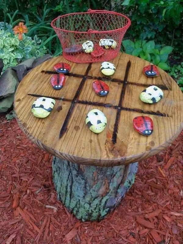 Những viên sỏi được dùng để tạo nên chiếc bàn xinh xắn. Sỏi được trang trí, vẽ thành những hình thù, những con vật đáng yêu giúp góc nghỉ trong vườn đẹp hơn.