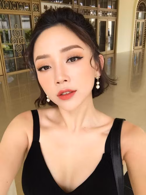 Cột hờ nửa phần tóc ở trên và uốn xoăn nhẹ nhàng phía dưới đuôi tóc giúp người đẹp Tóc Tiên nữ tính hơn rất nhiều.