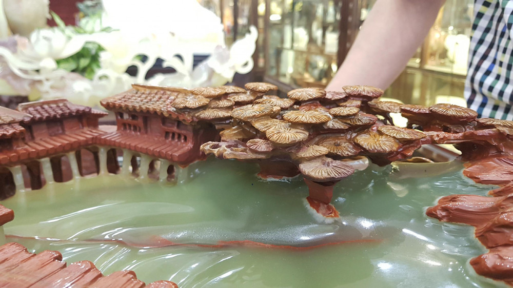 Bà Kiều Anh cho biết, tảng đá Onyx thô được nhập về từ Iran, sau đó, qua bàn tay tài hoa của những người thợ Việt Nam, tảng đá thô cứng, xấu xí được đục - đẽo - giũa trở thành một tác phẩm nghệ thuật có giá trị với nhiều chi tiết thuần Việt. Về tổng thể, bức tiêu cảnh "chốn bồng lai" được tạo kiểu giống như khung cảnh của một làng quê Việt Nam, với các chi tiết: Nhà mái ngói tựa đầu vào núi, những con trâu, những bông sen, lá sen,... hòa mình vào màu xanh ngọc bích của đá để tạo vẻ độc đáo, riêng biệt.