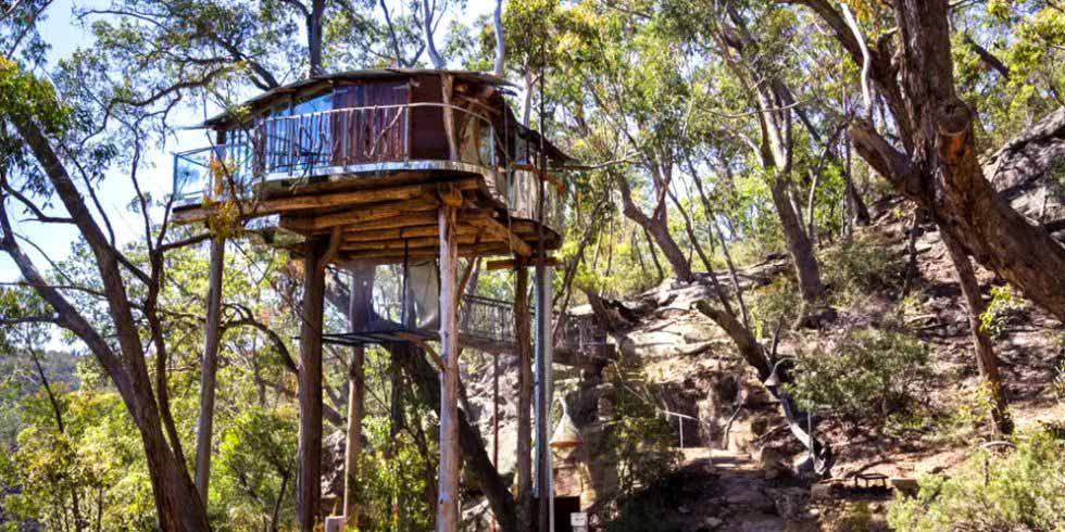 Ngôi nhà trên cây ở dãy núi Blue Mountains, Bilpin, Úc Khi bạn nhìn thấy phần bên trong của ngôi nhà trên cây này được bài trí tuyệt đẹp, và toàn bộ ngôi nhà được bao quanh bởi một khoảnh đất riêng rất lớn, bạn sẽ ước mơ được sống ở đây suốt đời. Cửa sổ kính suốt từ trần đến sàn ở tất cả các hướng giúp ánh sáng tự nhiên tràn vào và cho phép bạn ngắm toàn cảnh xung quanh.