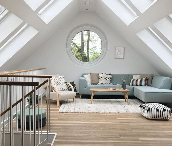 Phòng khách ngay trên tầng gác mái và tận dụng được khoảng sáng khi mái nhà được làm bằng kính.