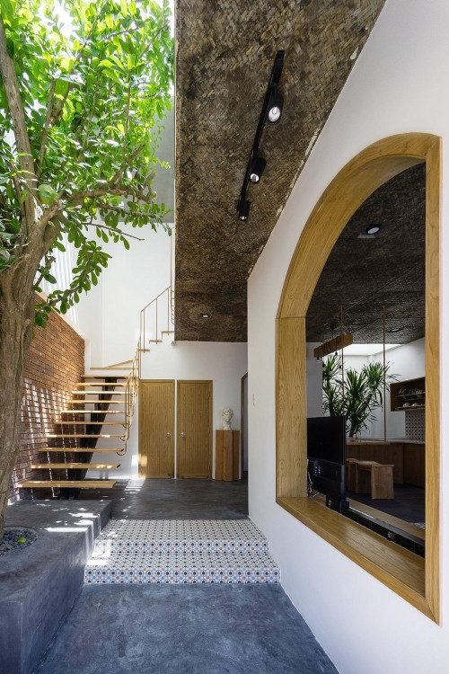 Sử dụng tường gạch, trần nứa và sàn bê tông thô giúp căn nhà trở nên đậm chất Á Đông, mộc mạc, khiêm nhường mà vô cùng ấm áp.