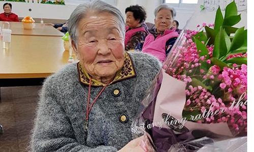 Bà Park được phóng viên tặng hoa tại nhà dưỡng lão. Ảnh: Chosun