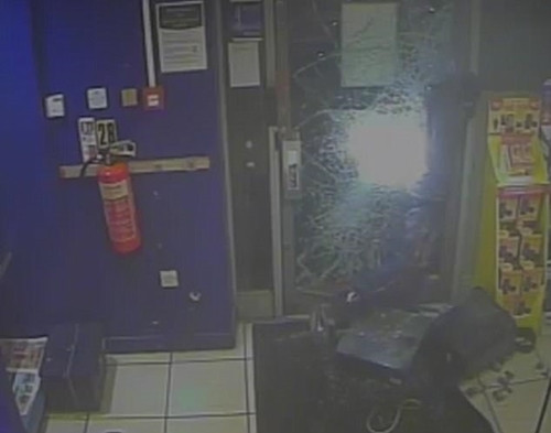 Tên trộm khó khăn lắm mới đập vỡ được 1 lỗ nhỏ trên cửa kính để thoát thân.