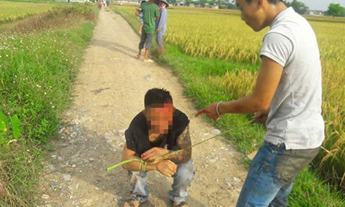 Đối tượng Lương bị người dân bắt giữ sau khi tham gia tấn công người lái máy gặt.