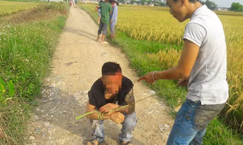 Đối tượng Lương bị người dân bắt giữ sau khi tham gia tấn công người lái máy gặt.