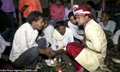 Người đàn ông mặc áo màu cam (vòng tròn đỏ) đã bắn vào chú rể ở cự li gần.