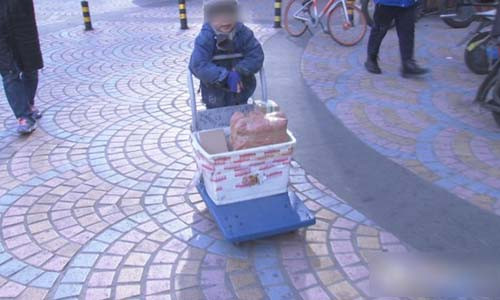 Cậu bé trong mặc một chiếc áo khoác mỏng, phần tay dài kéo xuống phủ kín bàn tay.