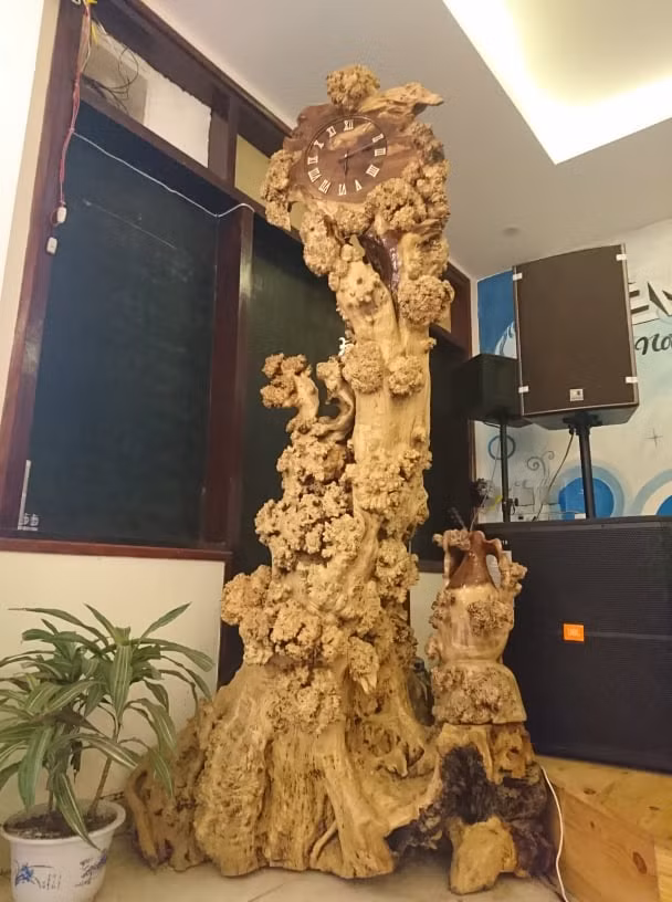 Anh Cường, chủ nhân của chiếc đồng hồ trên, chia sẻ, tất cả các bộ phận của chiếc đồng hồ đều làm từ thân cây me tự nhiên. Sau khi mang về, cây được bóc lớp vỏ ngoài và giữ lại nguyên bản nét xù xì của nó. Đường kính của thân cây khoảng 50cm, cao khoảng 2m. Phần đỉnh đầu được gắn chiếc đồng hồ quả lắc, chất liệu bằng gỗ. "Gốc me này tôi tìm mua được từ khu vực núi cao, thoạt nhìn bề ngoài thì không có gì đặc biệt, tuy nhiên để ý tỉ mỉ tôi hình dung ra nó phù hợp với một chiếc đồng hồ quả lắc. Càng quý hơn khi gốc me này thuộc hàng cổ thụ. May mắn là việc chế tác không quá vất vả". Anh Cường, chủ nhân của chiếc đồng hồ trên, chia sẻ, tất cả các bộ phận của chiếc đồng hồ đều làm từ thân cây me tự nhiên. Sau khi mang về, cây được bóc lớp vỏ ngoài và giữ lại nguyên bản nét xù xì của nó. Đường kính của thân cây khoảng 50cm, cao khoảng 2m. Phần đỉnh đầu được gắn chiếc đồng hồ quả lắc, chất liệu bằng gỗ. "Gốc me này tôi tìm mua được từ khu vực núi cao, thoạt nhìn bề ngoài thì không có gì đặc biệt, tuy nhiên để ý tỉ mỉ tôi hình dung ra nó phù hợp với một chiếc đồng hồ quả lắc. Càng quý hơn khi gốc me này thuộc hàng cổ thụ. May mắn là việc chế tác không quá vất vả".