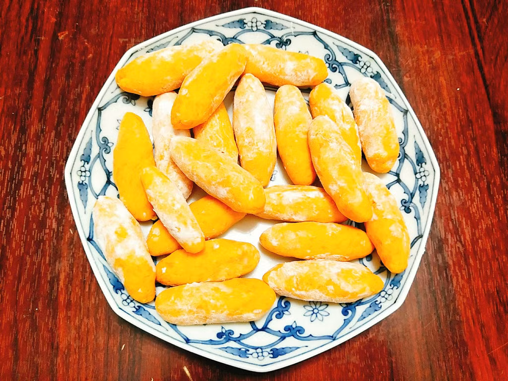 Ngắt từng ít khoai nặn thành hình cái kén sau đó lăn khoai vào 1/2 chỗ bột năng còn lại sao cho khoai lang kén bám đều một lớp mỏng bột bên ngoài.