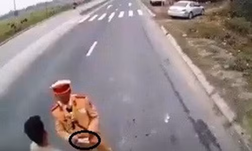 Một cảnh sát giao thông bị cho là nhận tiền mãi lộ trên quốc lộ 21. Ảnh cắt từ clip.