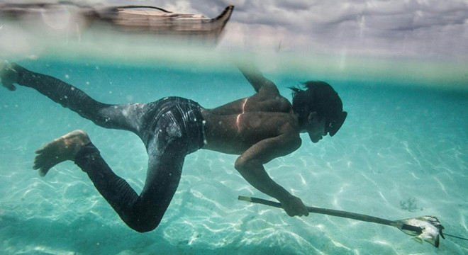 Một thanh niên tộc người Bajau lặn dưới biển bắt cá mà không cần tới dụng cụ hỗ trợ thở nào.