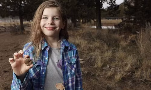Naomi cầm mẫu hóa thạch cô bé tìm thấy. (Nguồn: AP)