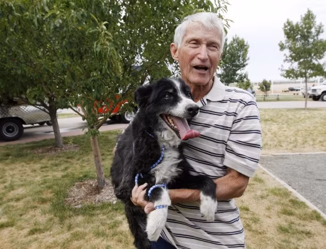 Một người đàn ông ôm con chó của mình sau khi nó được cứu từ trận hoả hoạn.