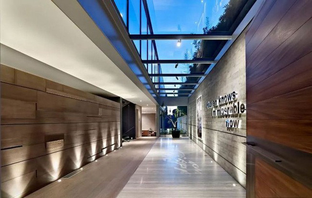 Nhờ sở hữu diện tích hơn 800m², hai nhà thiết kế có thừa không gian để tạo nên một thảm cỏ rộng lớn. Không gian lộ thiên xanh mát này vừa giúp giảm nhiệt mùa hè, vừa là nơi thư giãn, tắm nắng hoặc tổ chức các buổi tiệc ngoài trời. Dãy cửa sổ trần mở ra không gian tràn ngập ánh sáng cho khu sảnh.