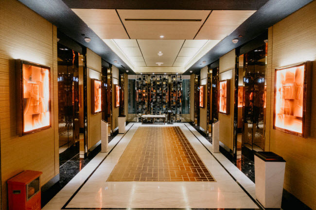 Hành lang dọc các phòng nghỉ của khách được trang trí xa hoa với ánh sáng màu kim loại và vàng.