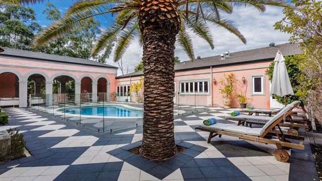 Ngôi nhà nhà màu hồng này mang phong cách của một khu nghỉ mát với bể bơi, cây xanh, giường tắm nắng…