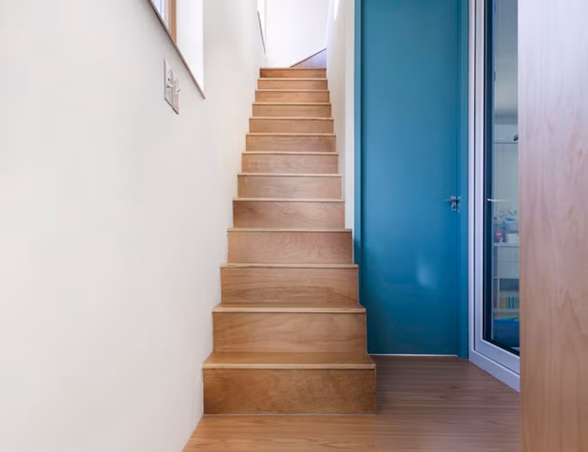 Lối cầu thang nhỏ với màu gỗ tự nhiên tiết kiệm diện tích tối đa mà vẫn đủ đáp ứng nhu cầu của người sử dụng.