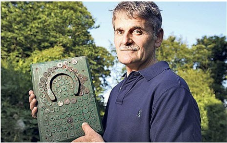 Cháu nội của John Hugill cầm trên tay những đồng xu may mắn ngày đó.