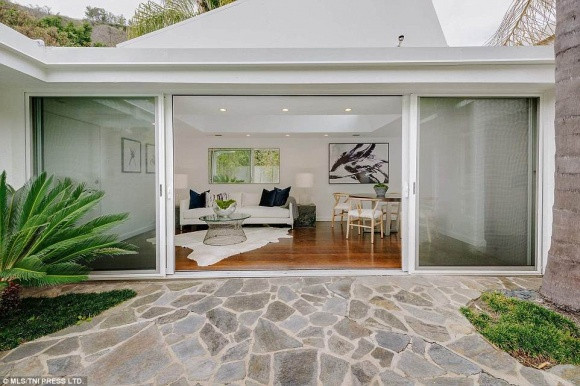 Điểm cộng của căn nhà là có phòng khách rộng lớn với trần nhà cao cùng cửa dẫn ra khu vườn tươi mát bên ngoài. Ngoài ra cơ ngơi trên còn có hồ bơi xanh trọng được bao quanh bởi cây cối và núi non. Trong nhà còn có cả một hầm rượu vang với sức chứa lên đến cả nghìn chai.