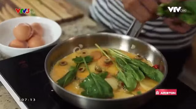 Trước khi cho vào lò nướng, bạn cho ô-liu và cải bó xôi lên trên trứng.