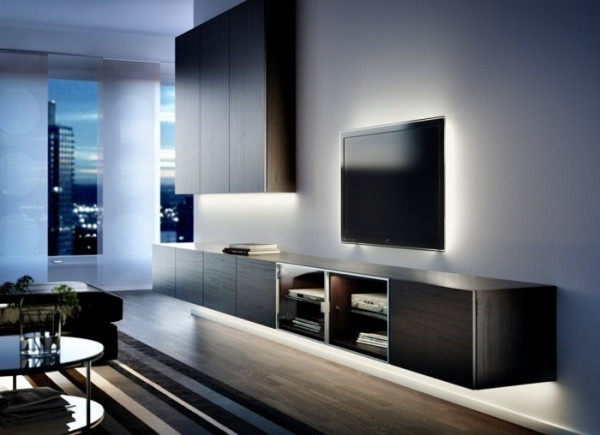 Khu vực sinh hoạt chung của gia đình được bố trí, thiết kế đơn giản với hệ thống kệ kết hợp với tủ đựng đồ. Tất cả khoảng tường bao quanh đồ nội thất và đồ gia dụng đều được nhấn nhá với ánh sáng sẽ thêm tinh tế và ấn tượng hơn nhờ hệ thống đèn Led tạo đường viền nổi bật.