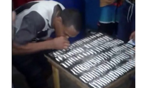 Một tù nhân đang hít ma túy trên bàn.