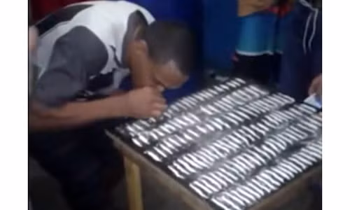 Một tù nhân đang hít ma túy trên bàn.