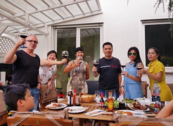 Hình ảnh gia đình vui vẻ quây quần trong bữa ăn với bạn bè ở Đức.