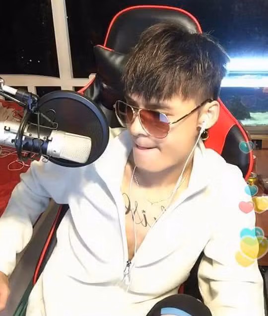 Diện sơ mi + đeo kính đen là "combo" thường thấy mỗi khi Hoa Vinh livestream. Ảnh chụp màn hình.