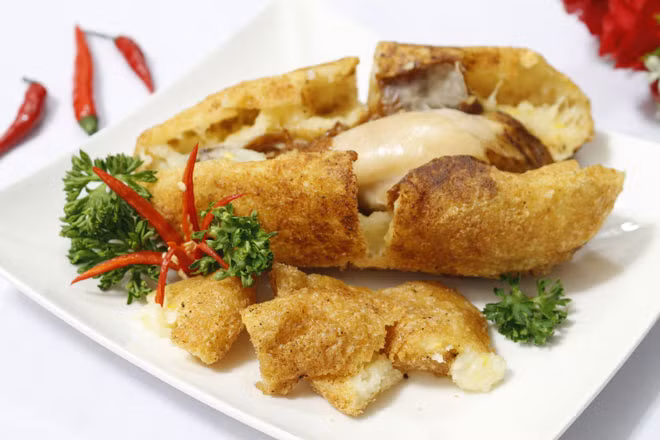 Khi ăn bạn dùng kéo cắt phần vỏ xôi ra thành các miếng vừa ăn, chấm tương ớt ăn kèm với xà lách, rau mùi, dưa leo và thưởng thức khi còn nóng sẽ ngon hơn.