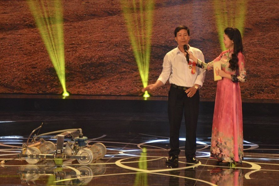 Anh Phạm Văn Hát (áo trắng) giới thiệu về Robot đặt hạt.