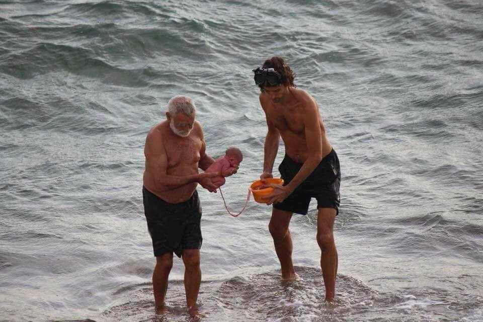 Bác sĩ sản khoa và bố đứa trẻ đưa em bé lên bờ (Ảnh: Jana Tours Egypt)