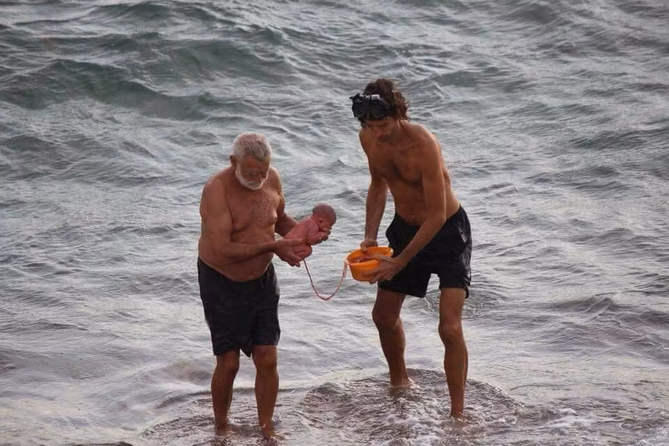 Bác sĩ sản khoa và bố đứa trẻ đưa em bé lên bờ (Ảnh: Jana Tours Egypt)