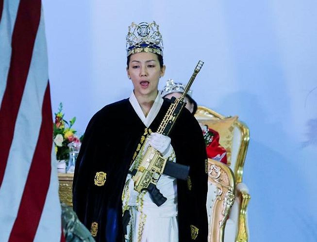 Một mục sư của nhà thờ cầm khẩu súng trường mạ vàng.