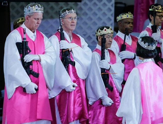 Các linh mục nhà thờ mặc trang phục màu trắng và hồng cầm theo súng trường AR-15 trong buổi lễ.