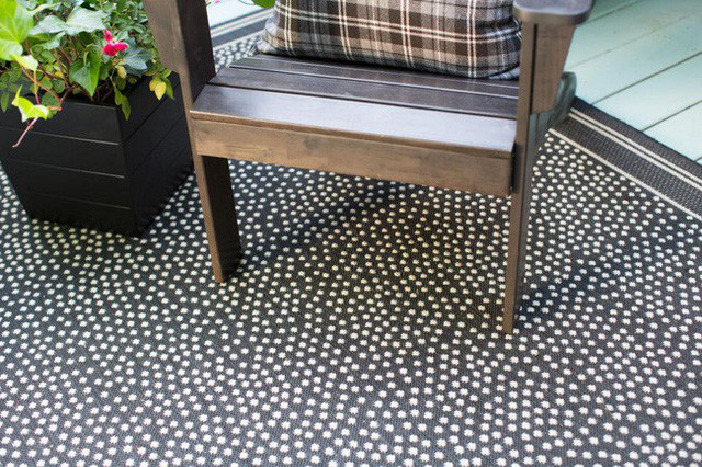 Chiếc ghế gỗ đúng màu nguyên bản, kết hợp với gối tựa, sàn nhà chấm bi là điểm nhấn thú vị khi làm mới hiên nhà bạn.