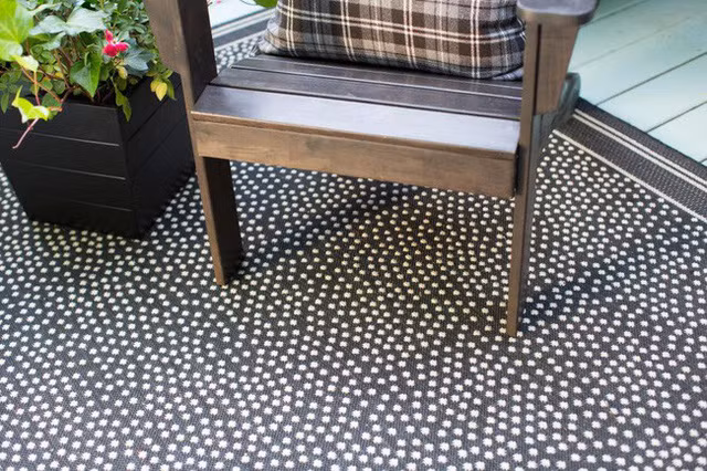 Chiếc ghế gỗ đúng màu nguyên bản, kết hợp với gối tựa, sàn nhà chấm bi là điểm nhấn thú vị khi làm mới hiên nhà bạn.