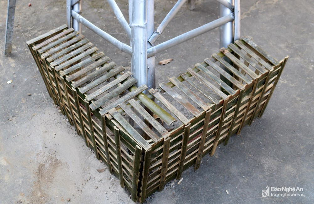 Mỗi chân tháp được cố định bằng một cọc gỗ chôn xuống nền xi măng và cách điệu phía ngoài. Ảnh: Huy Thư