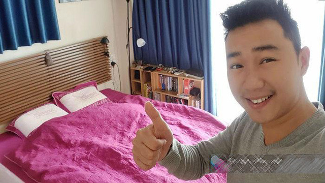 Phòng ngủ rực rỡ của đôi vợ chồng trẻ với bộ ga gối màu hồng kết hợp với rèm cửa màu xanh.