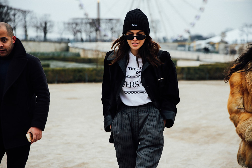 Không chỉ tín đồ thời trang, trang phục của các người mẫu cũng là điểm thu hút tại những kinh đô lớn trên thế giới. Họ lăng xê các xu hướng thời trang độc đáo mỗi khi xuất hiện trên phố. Kaia Gerber nam tính trong set đồ menswear kết hợp giữa blazer độn vai, áo thun trắng in logo cùng quần tây kẻ sọc. Trào lưu kết hợp trang phục cùng kính mắt mèo bản nhỏ cũng được lòng con gái siêu mẫu Cindy Crawford.