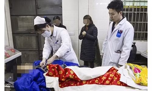 Ông Huang vẫn còn sống thời điểm được đưa đến nhà tang lễ. Ảnh: SCMP