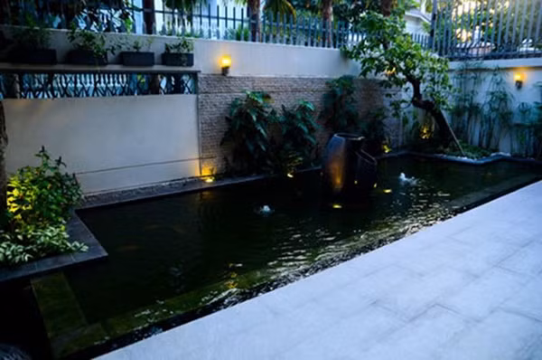 Ngoài cây xanh, khu hồ nước còn được lắp hệ đèn hắt tạo điểm nhấn, hình khối và chiếu sáng khi trời tối, giúp sân vườn biệt thự lung linh, sinh động.