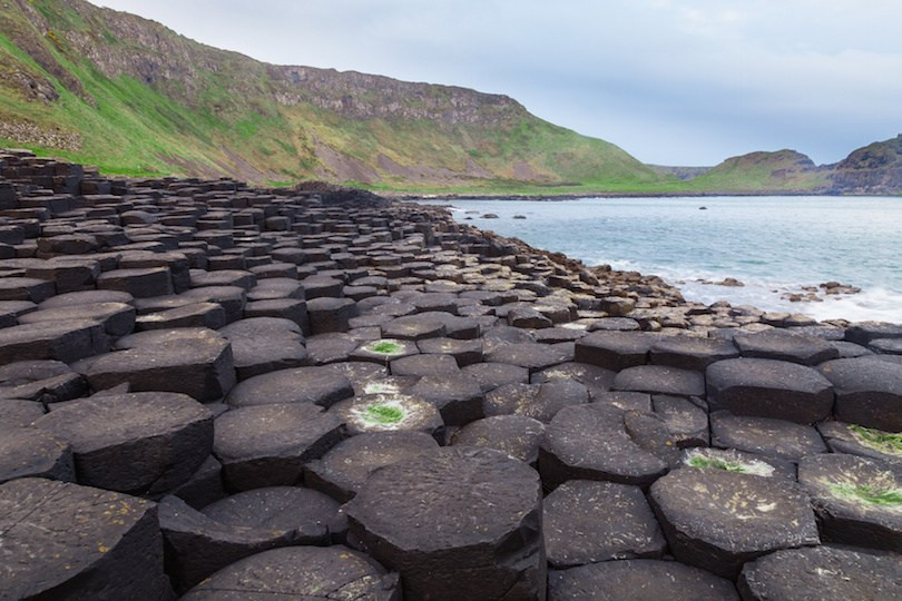 2. Giant's Causeway Giant's Causeway nằm trên bờ biển Antrim tuyệt đẹp của Đảo Bắc Island, bao gồm các khối đá hình đa giác. Một số cột rất cao, trong khi những khối khác tương đối bằng phẳng, chúng đứng san sát bên nhau tạo ra một trong những kỳ quan ấn tượng nhất trên trái đất. Theo truyền thuyết, một người khổng lồ Ai Len đã dựng nên những khối đá san sát này để có thể băng qua biển, chống lại một người khổng lồ người Scotland. Nhưng thực tế, sự hình thành các khối đá cân xứng này là kết quả của vụ phun trào núi lửa xảy ra cách đây 50 đến 60 triệu năm.